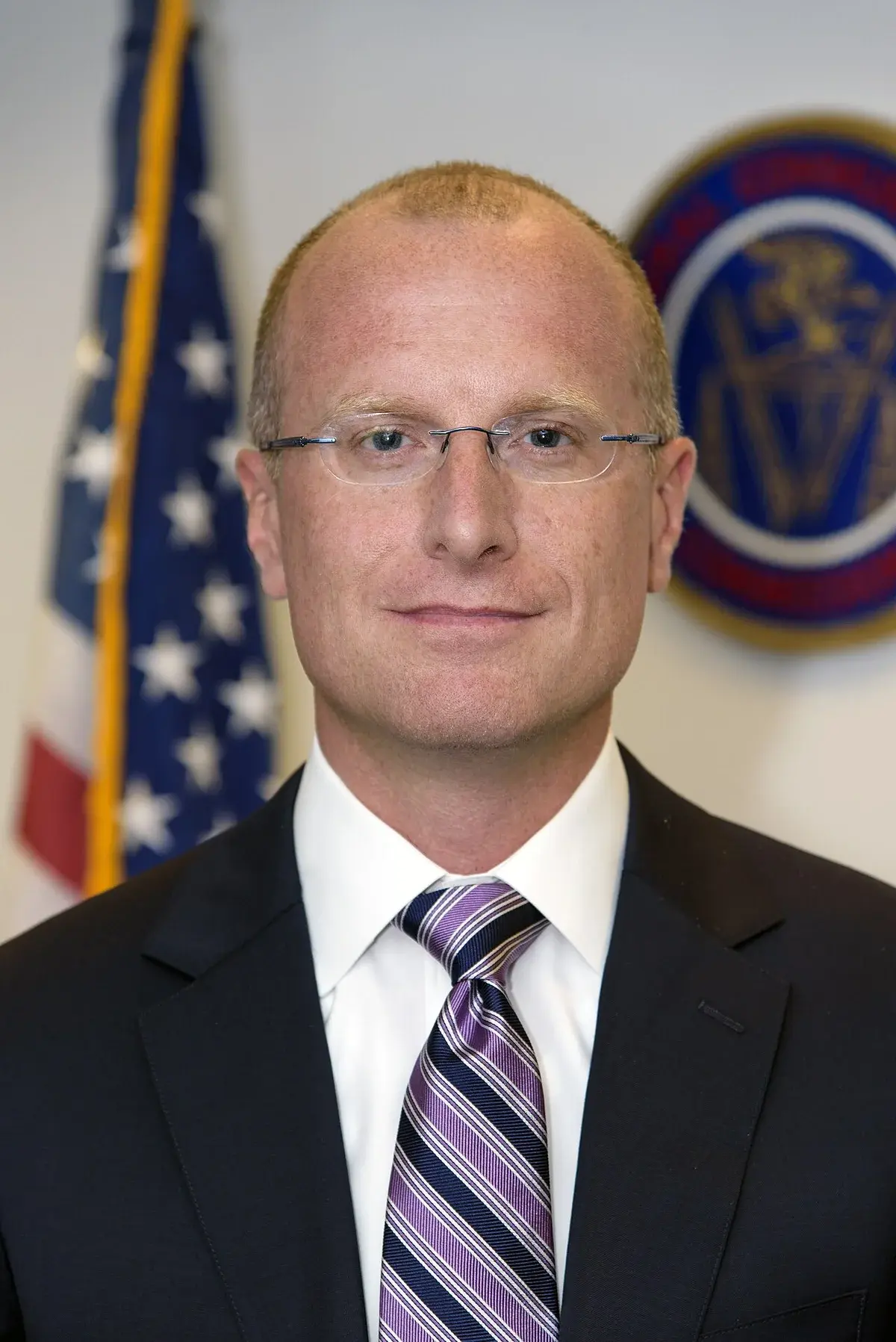 Official portrait of Brendan Carr in front of a U.S. flag and FCC seal.