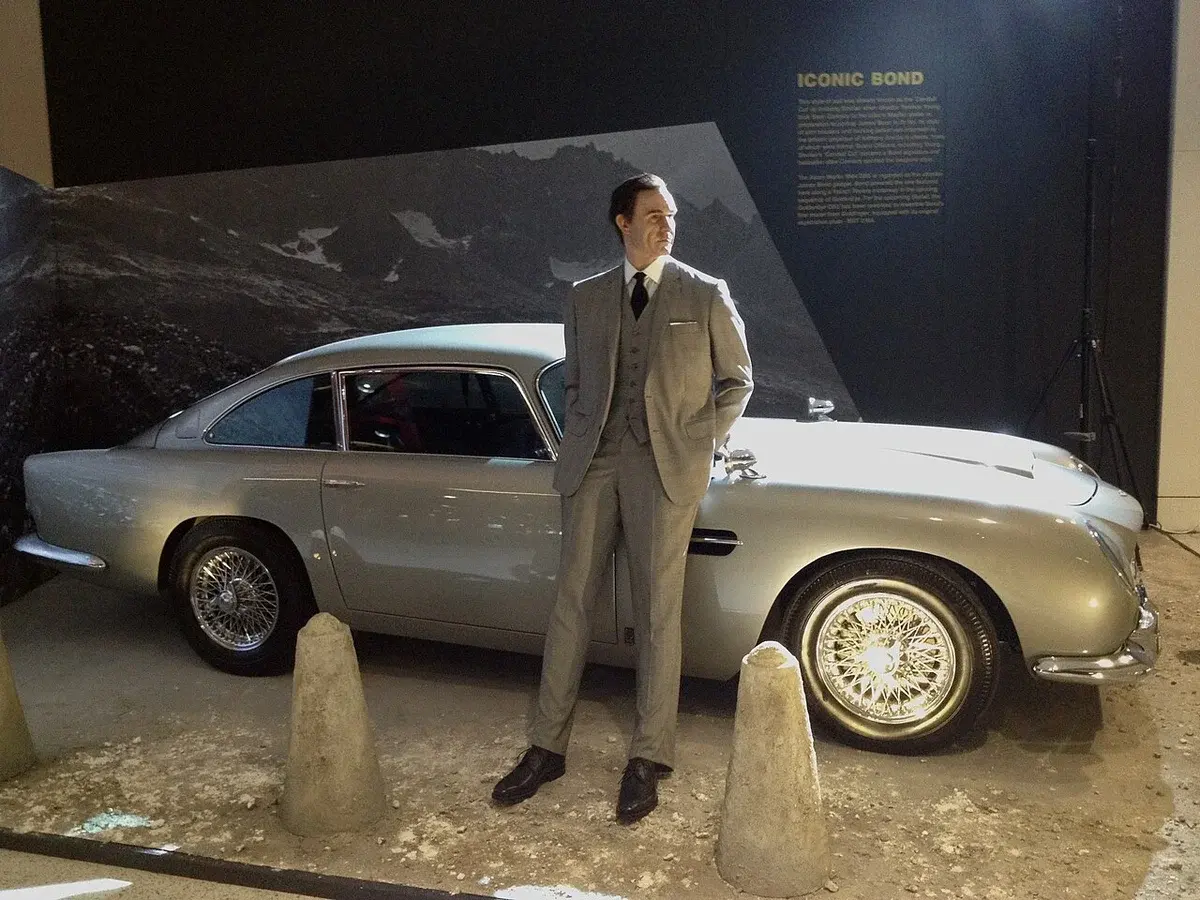 Aston Martin DB5 on display with a James Bond figure in front of it.
