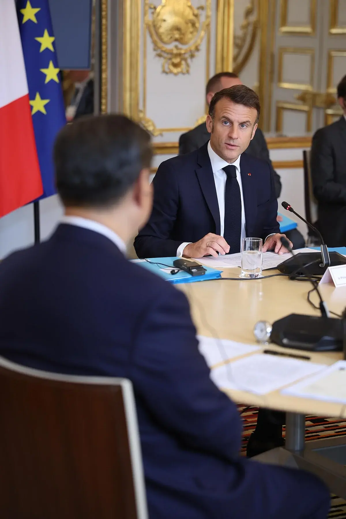 Emmanuel Macron seated at a conference table during an official meeting in Paris.