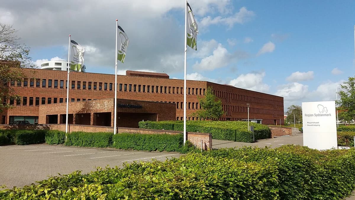 Region Syddanmark building with flags and a sign outside.