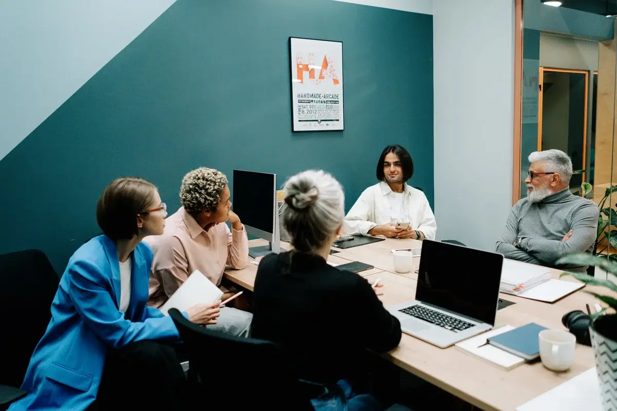 A diverse team meeting around a table in a modern office.
