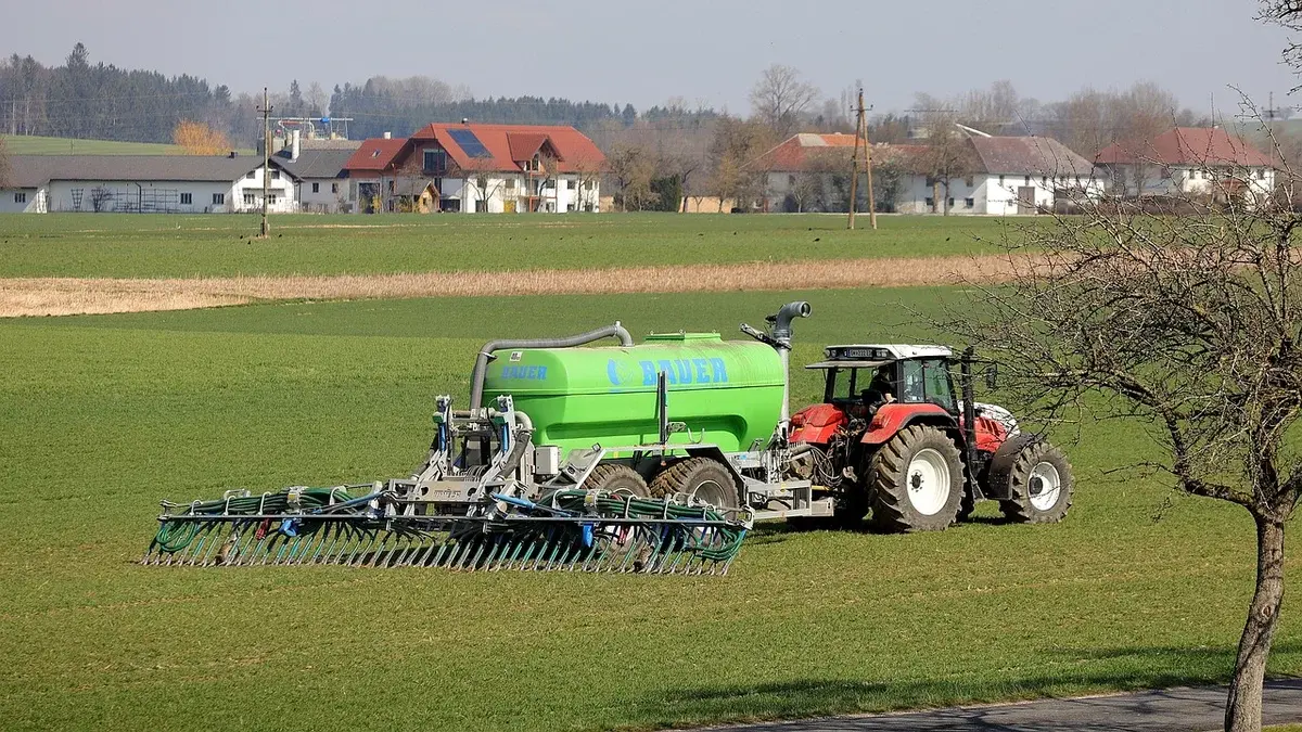 A tractor spreading slurry on a field.