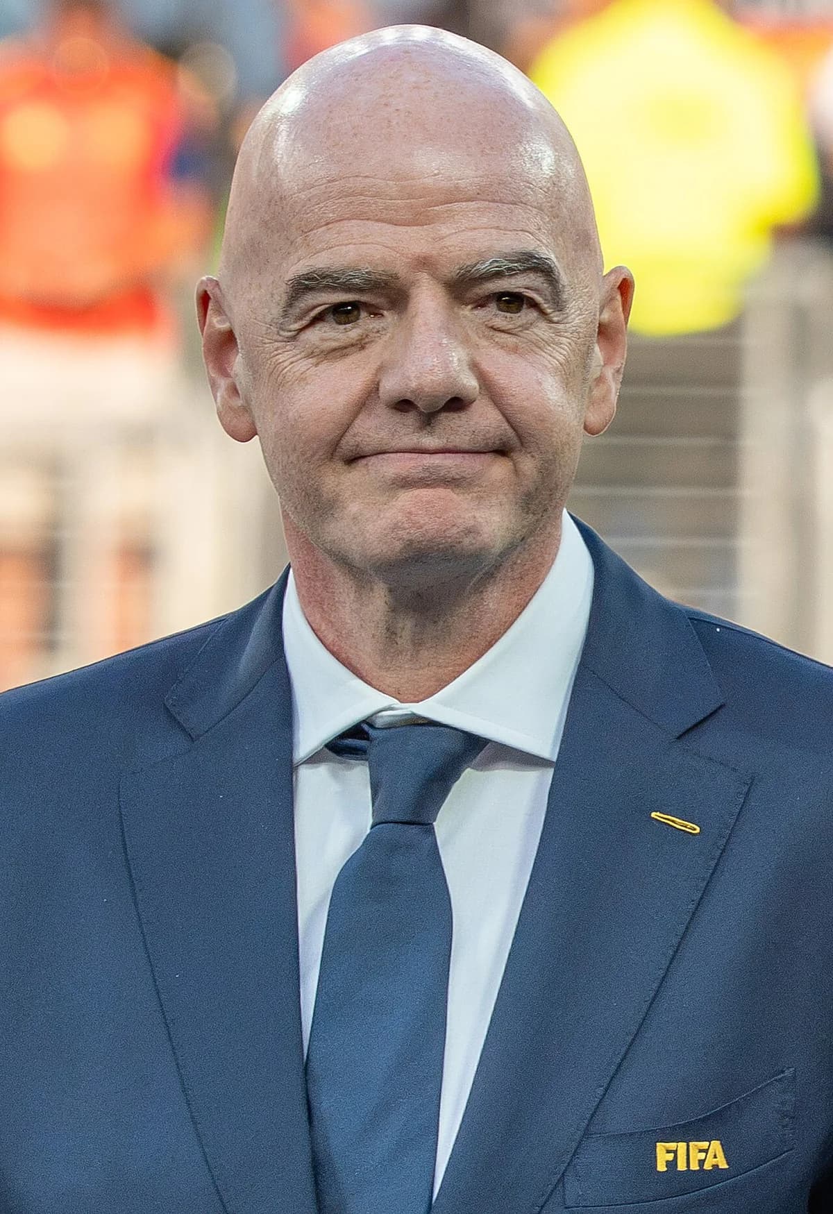 Close-up portrait of Gianni Infantino in a dark blue FIFA suit and tie.