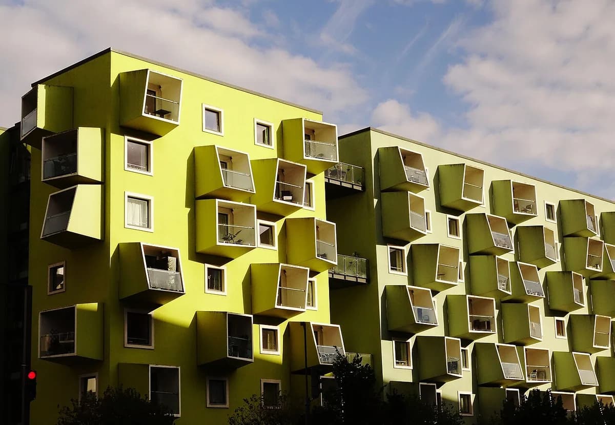 Modern green apartment-like care building with many projecting window boxes.