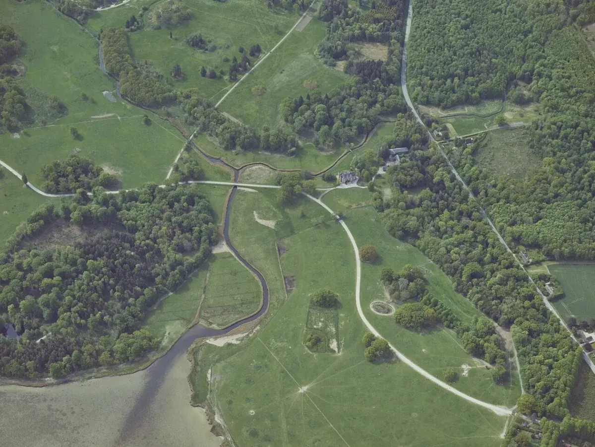 Oblique aerial view of Knuthenborg Safaripark with green fields, trees, and paths