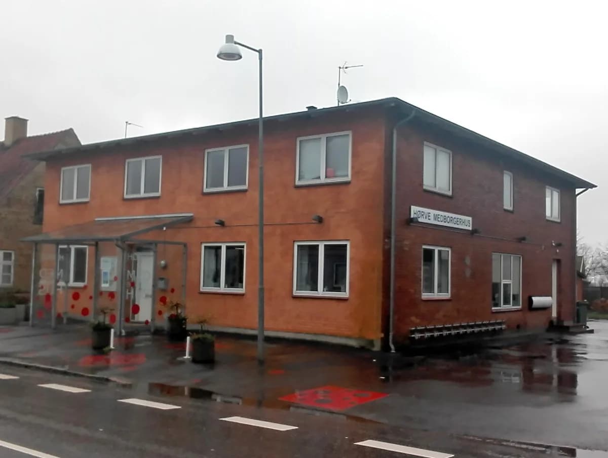 Exterior of Hørve Community House on a rainy day.