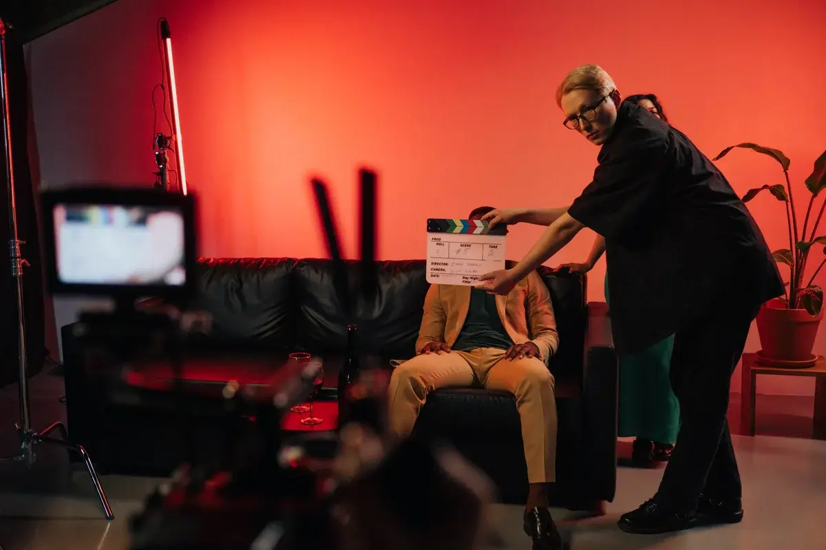 Film crew shooting a scene with dramatic red lighting indoors