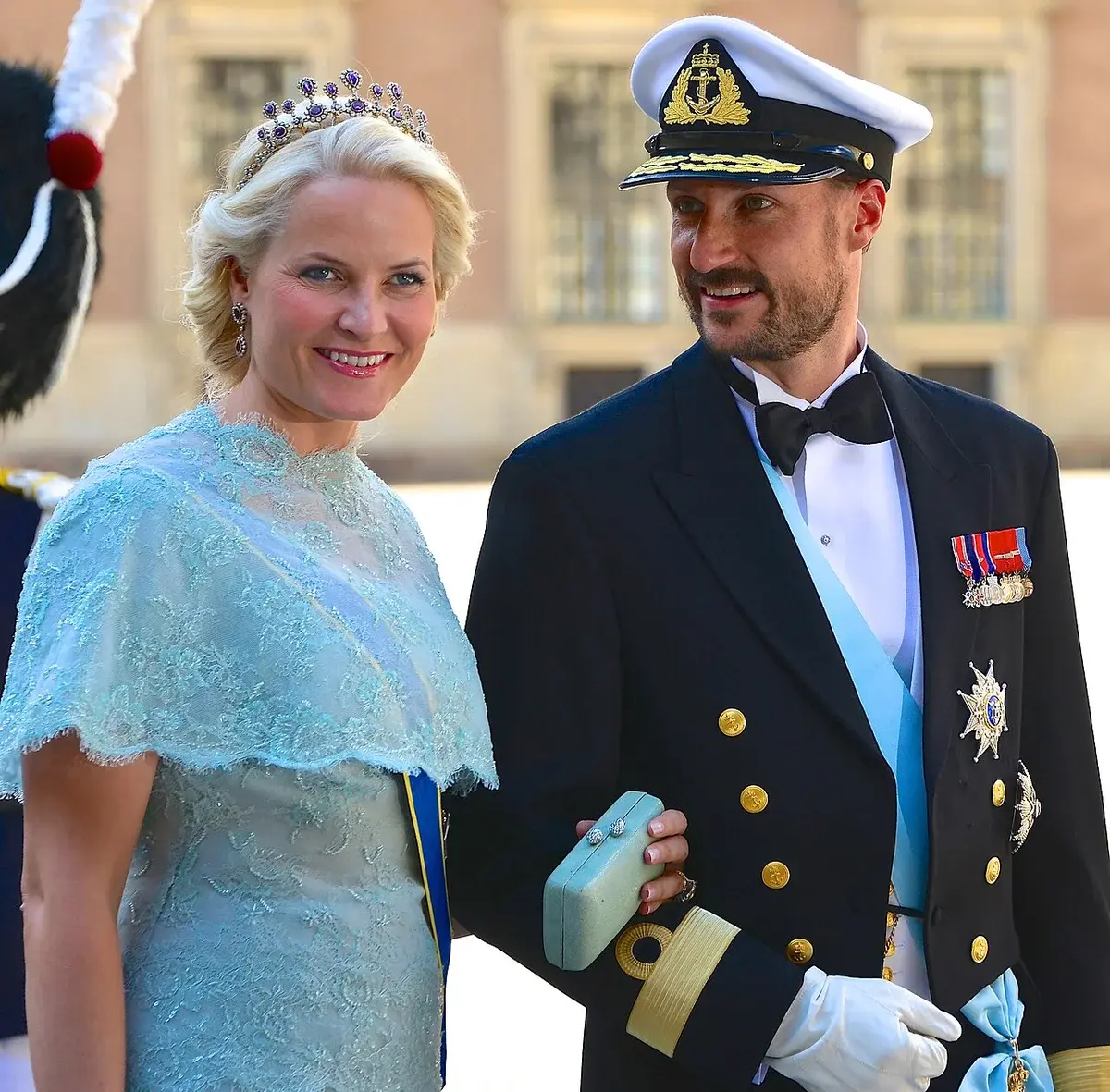 Crown Prince Haakon and Crown Princess Mette-Marit of Norway standing together in formal royal attire in Stockholm.