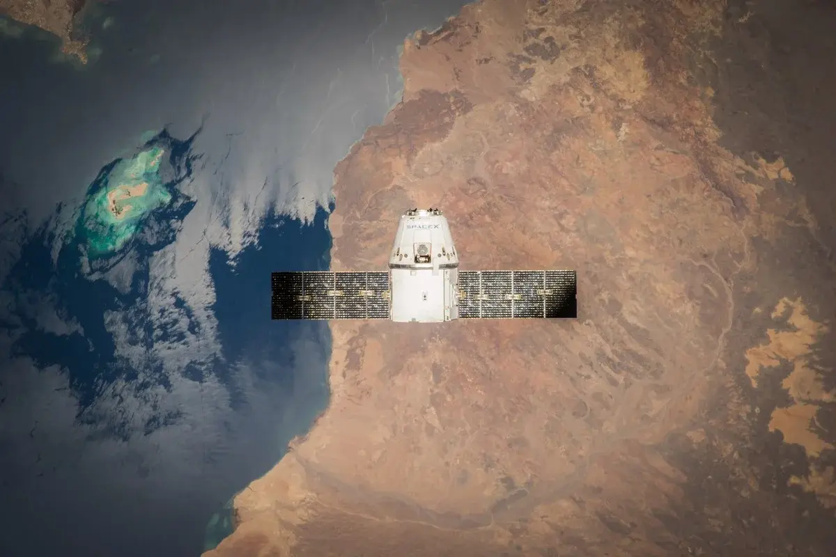 A satellite orbiting above Earth with ocean and land visible below.