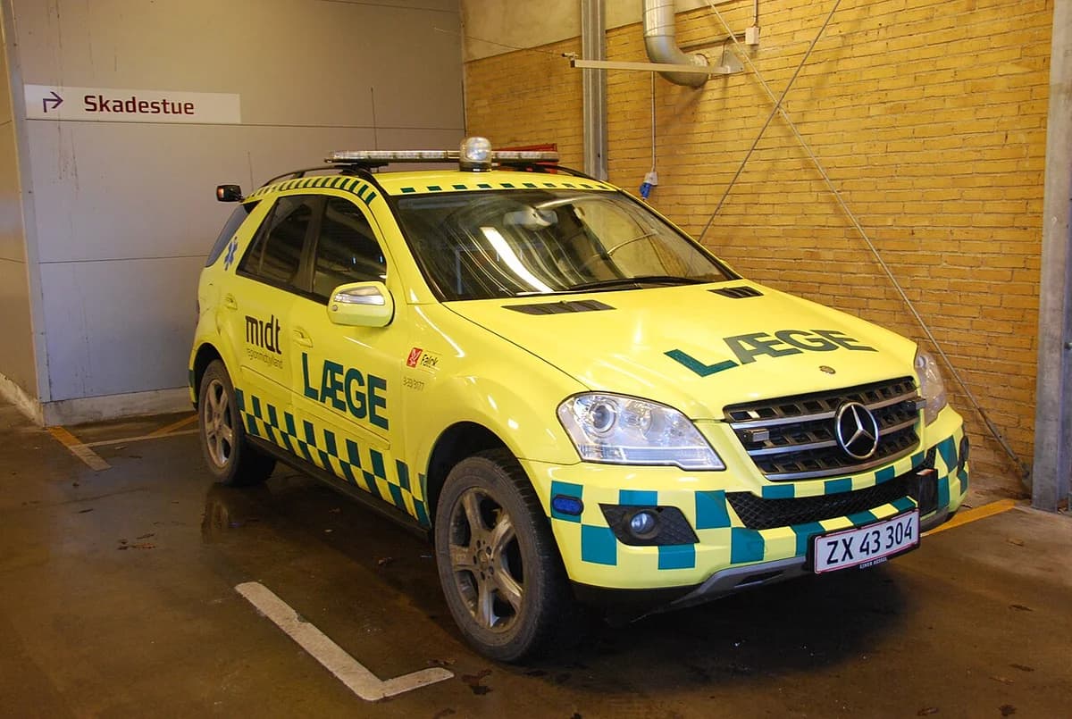 Yellow emergency doctor vehicle parked indoors near an emergency department sign.