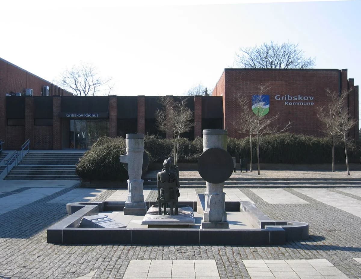 Gribskov Town Hall building with a plaza and sculpture fountain in front.