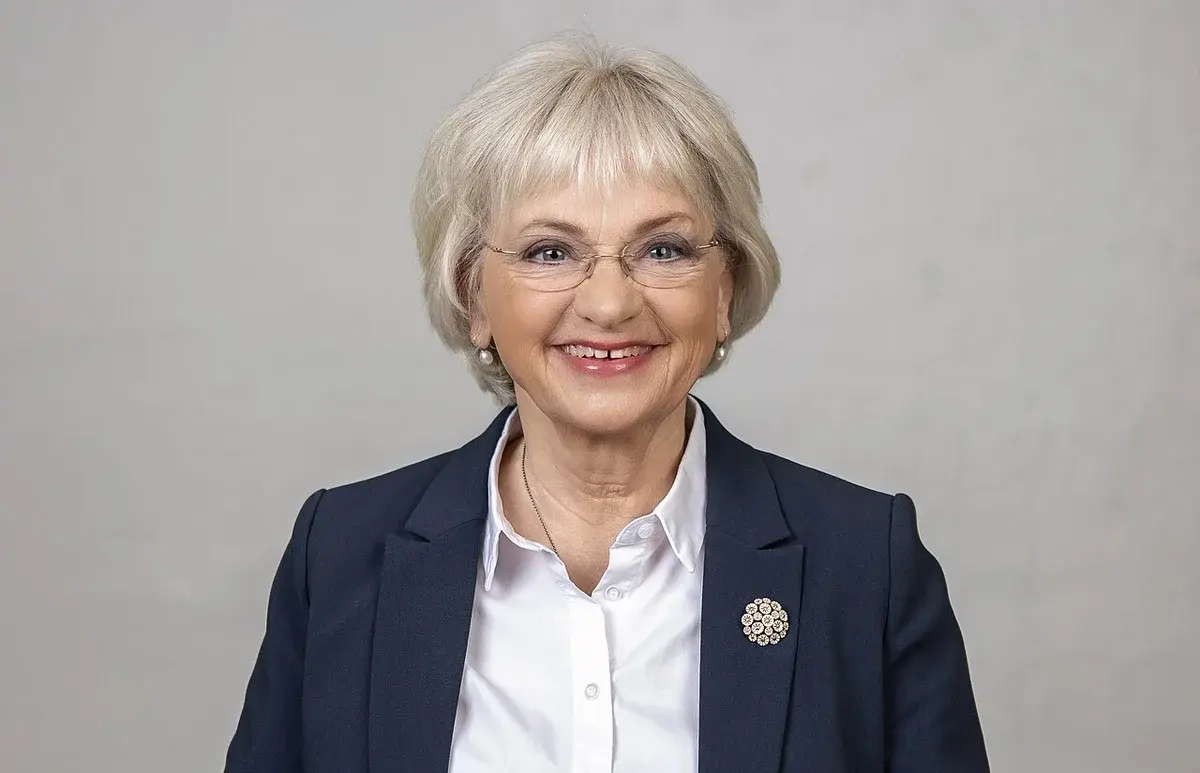 Formal portrait of Pia Kjærsgaard smiling in a blazer and white shirt.