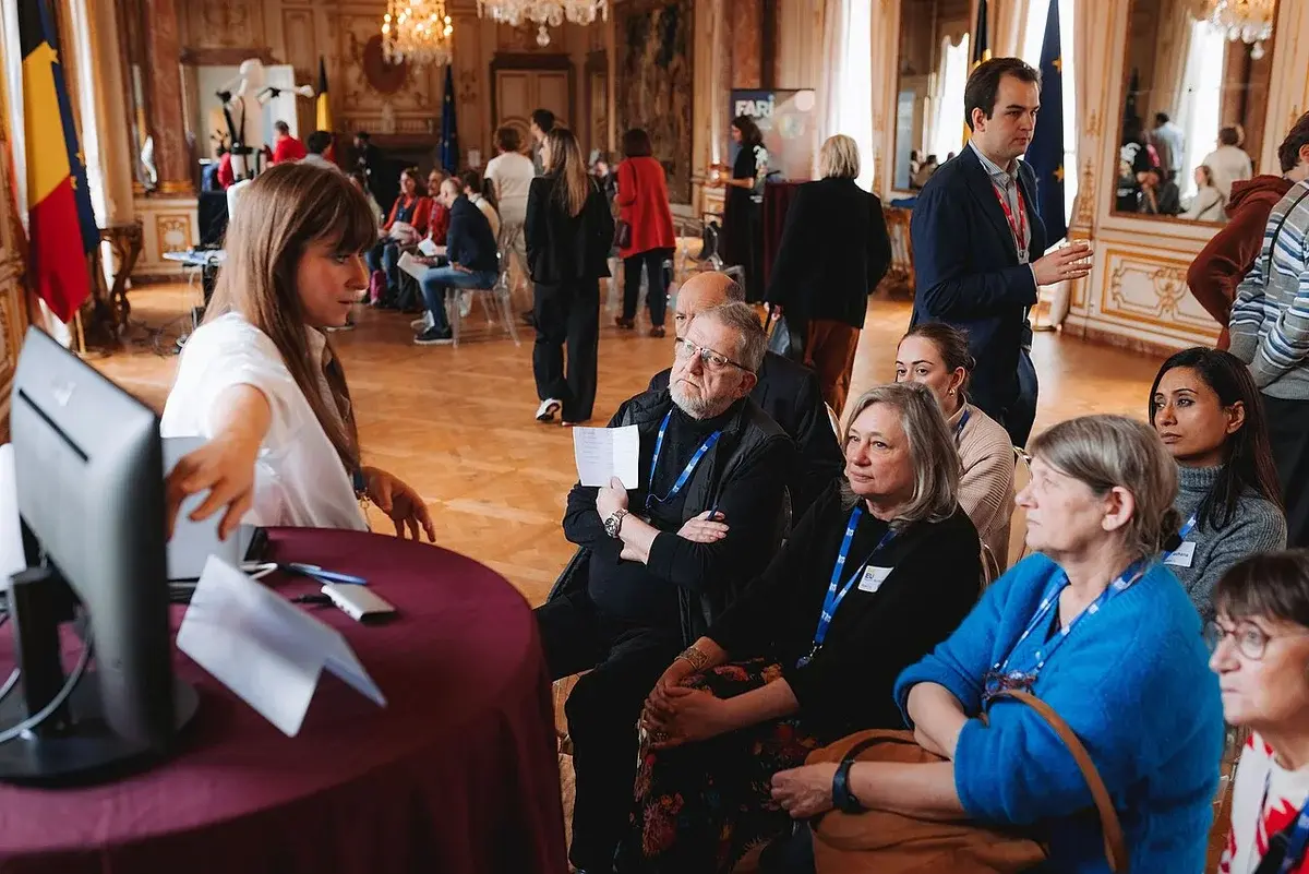 People attending a citizen panel in an ornate hall in Brussels.