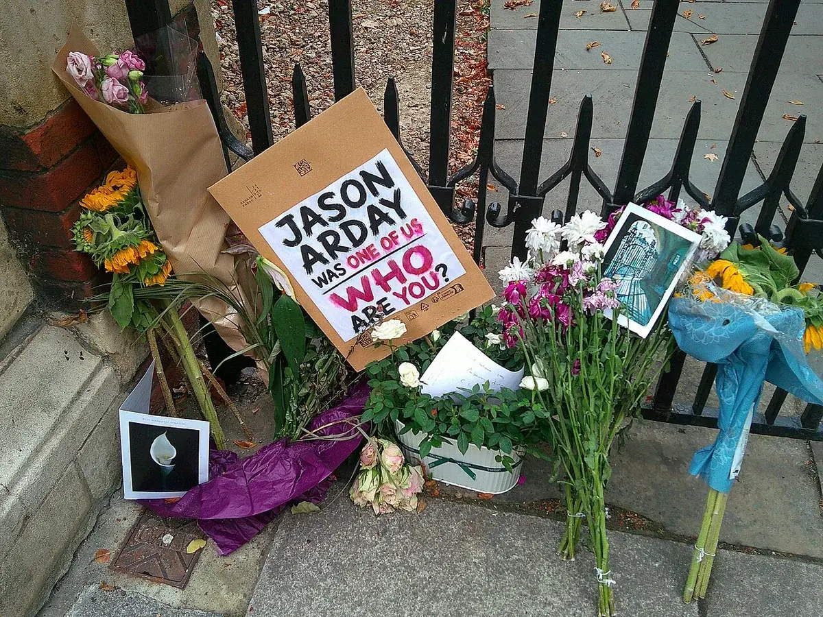 Flowers and signs left as a tribute outside Jesus College in Cambridge.