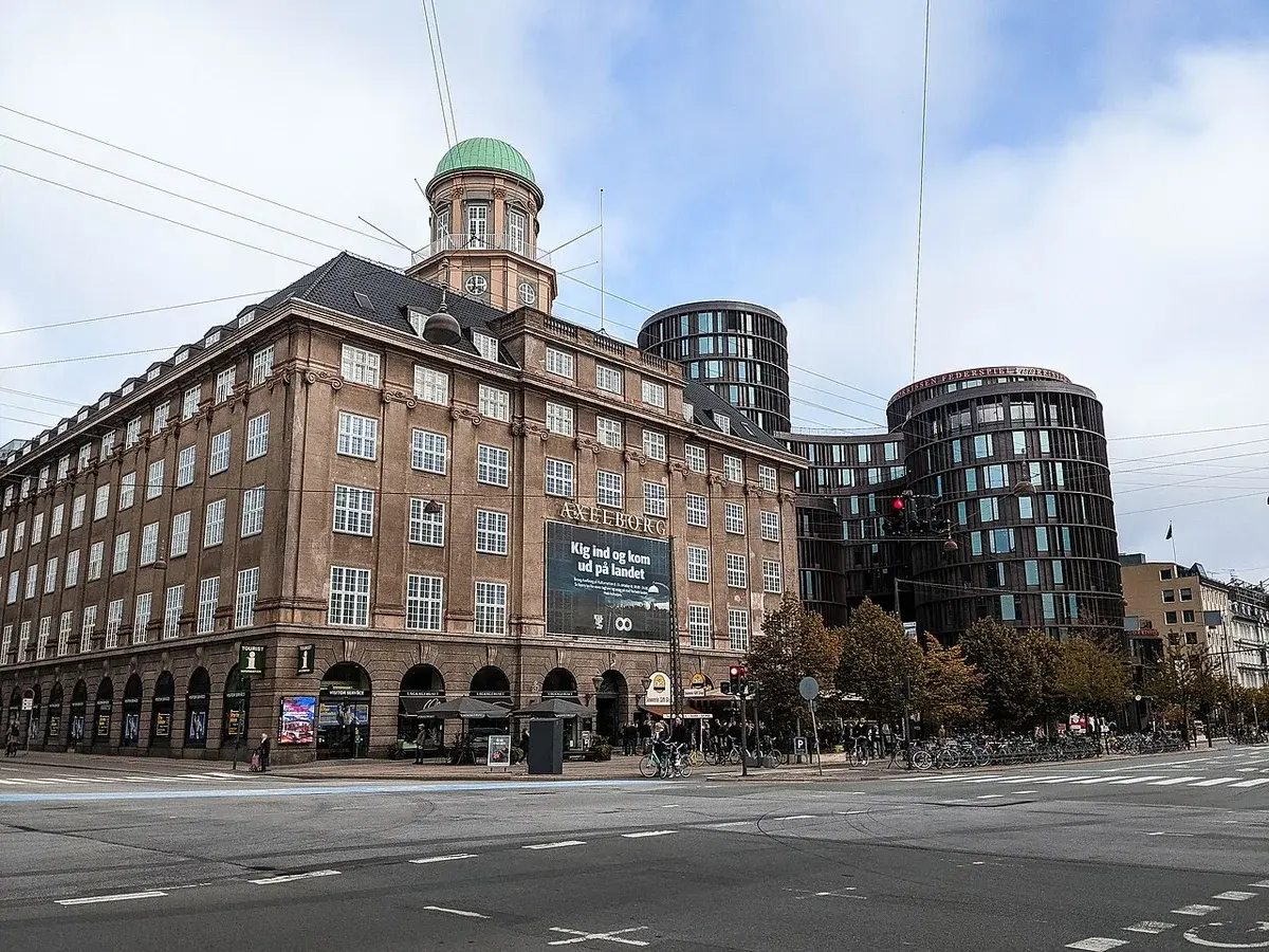 Axelborg building in Copenhagen at a city intersection.