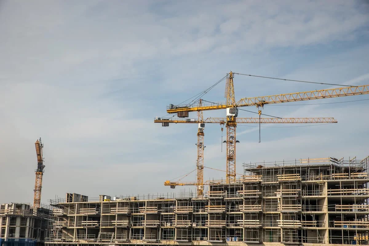 Construction site with cranes and a building under construction.