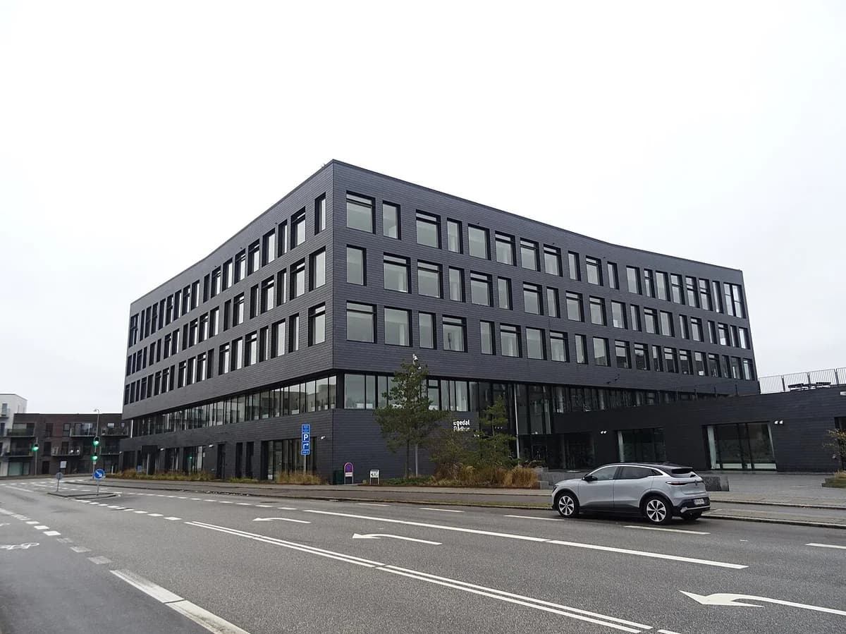 Modern dark town hall building beside a quiet street in Denmark.