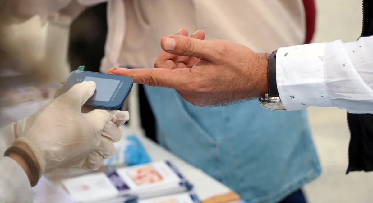 Healthcare professional checking blood sugar on finger at event