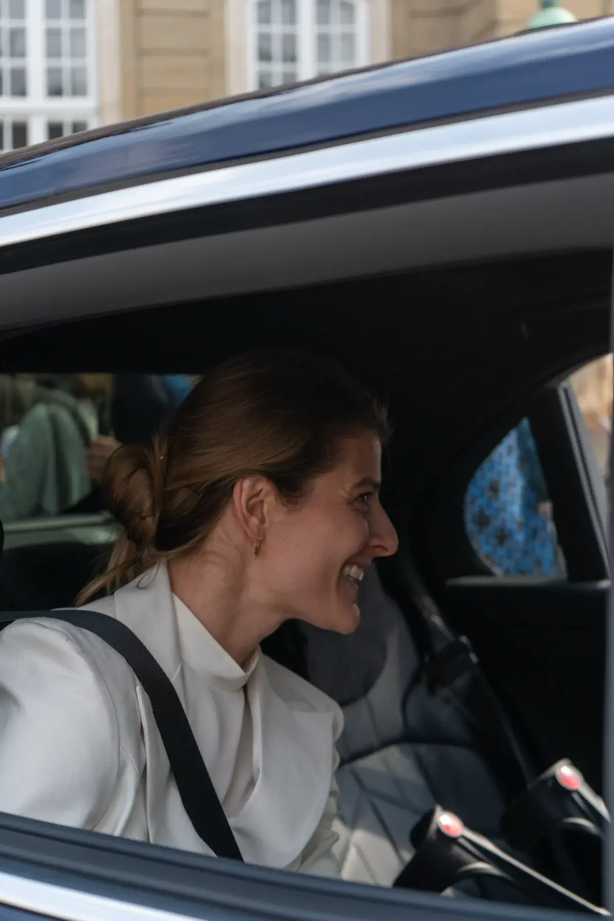 Ane Halsboe-Jørgensen smiling inside a car after a ministerial appointment.