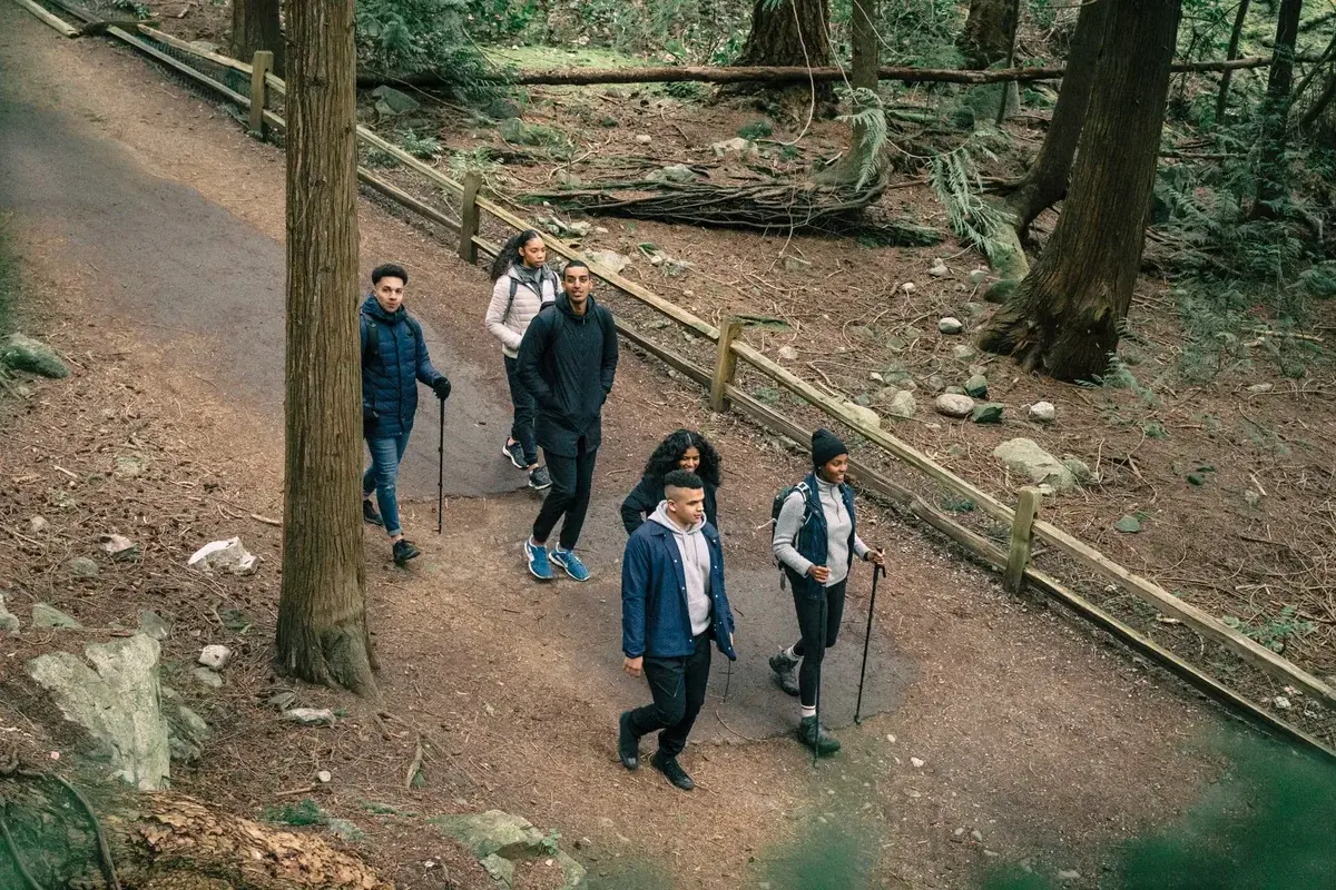 A group of friends hiking on a forest trail.