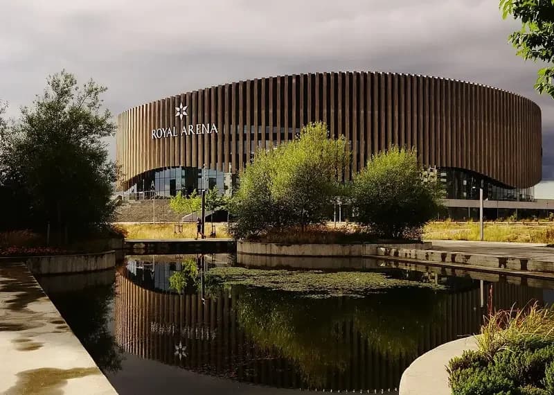Exterior view of Royal Arena in Copenhagen beside a pond.