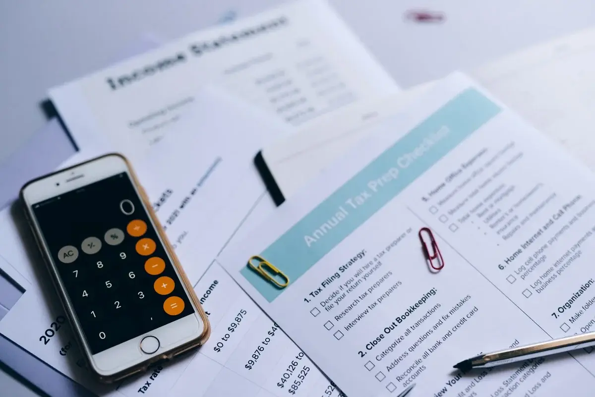 Tax documents and smartphone calculator on desk