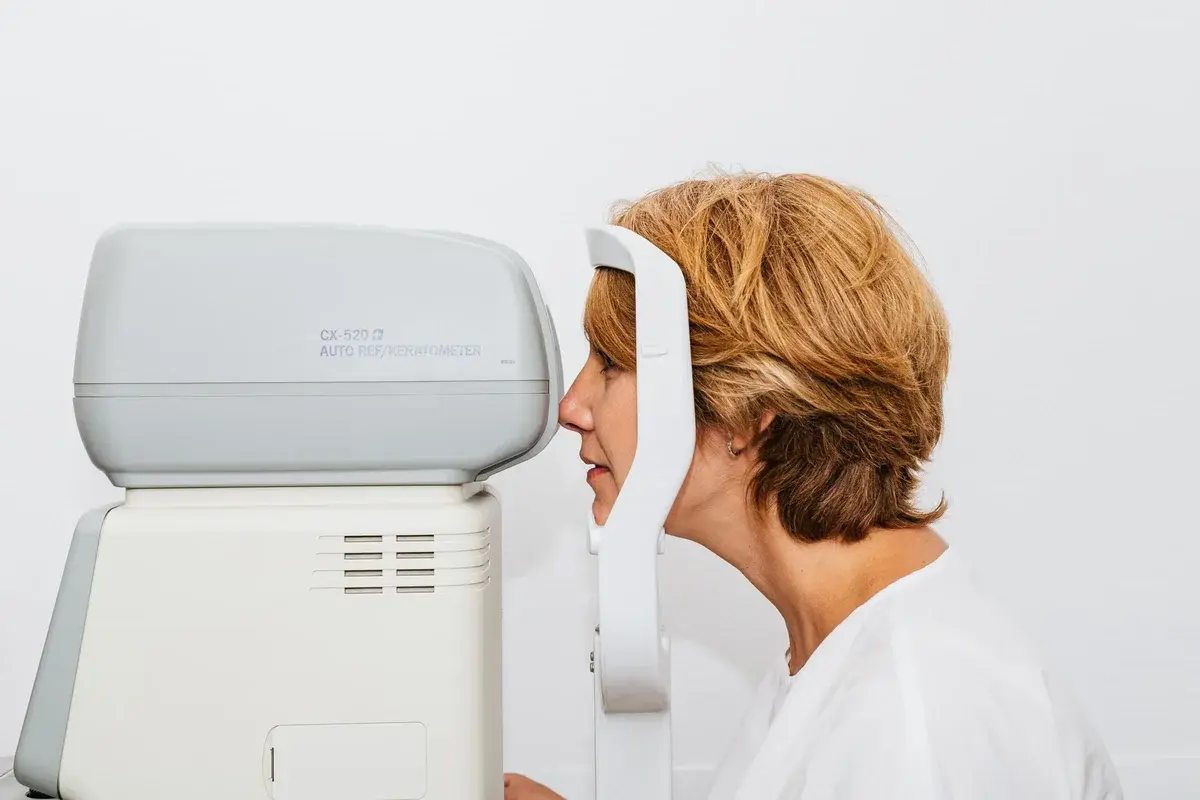 Woman having an eye exam with an autorefractor.