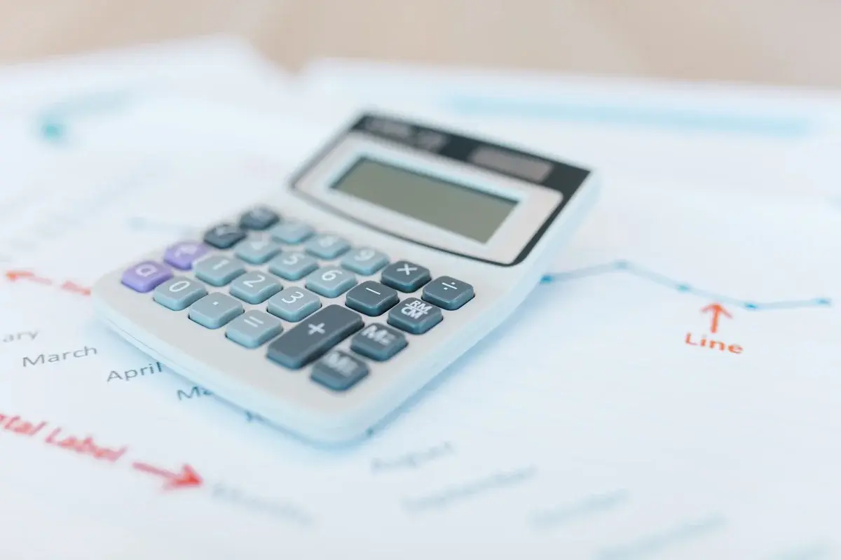 A calculator lying on top of financial charts and documents.