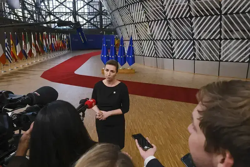 Danish Prime Minister Mette Frederiksen speaking to reporters inside the European Council building