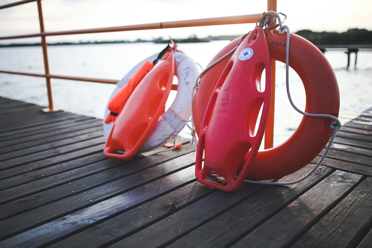 Life-saving rings and buoys on wooden dock near water
