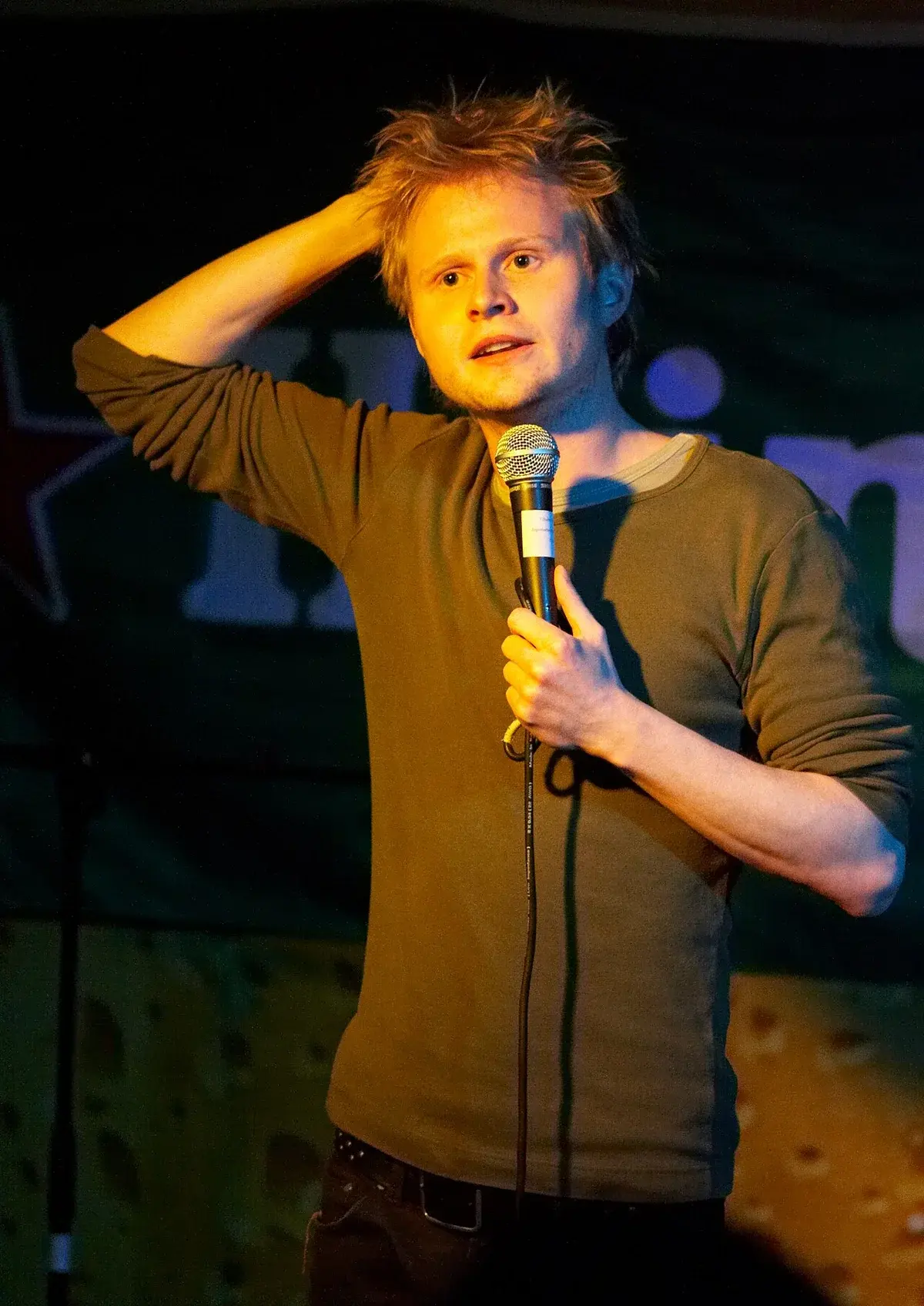 Jonatan Spang standing on stage with a microphone.