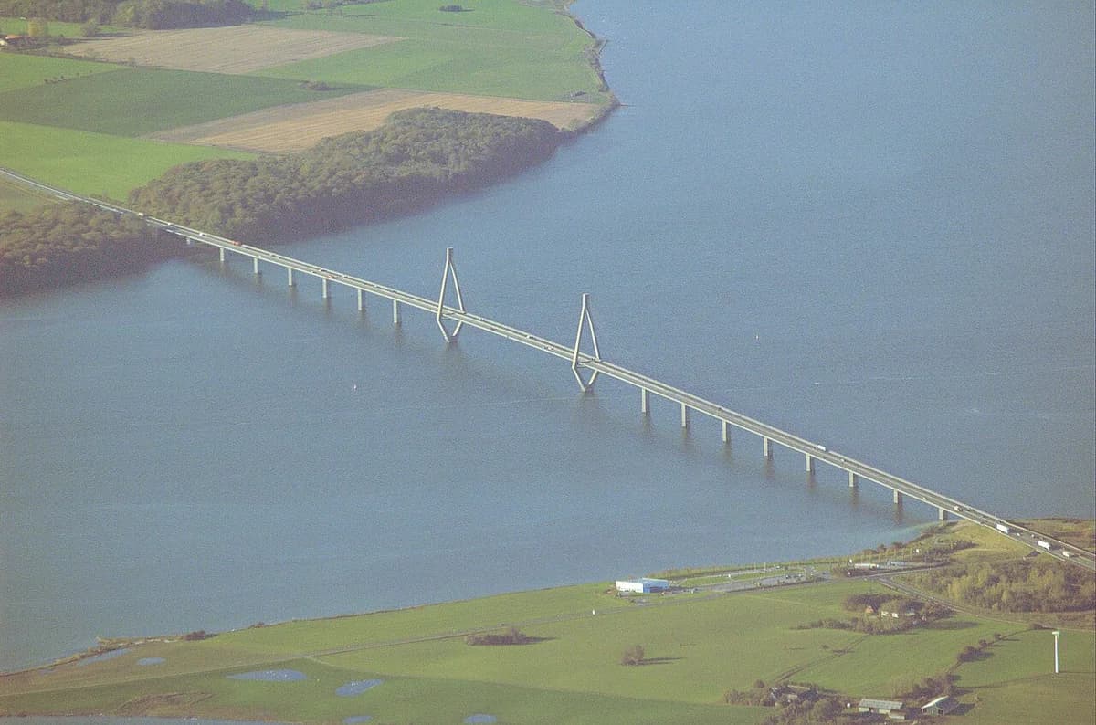 Aerial view of a bridge crossing water beside farmland.