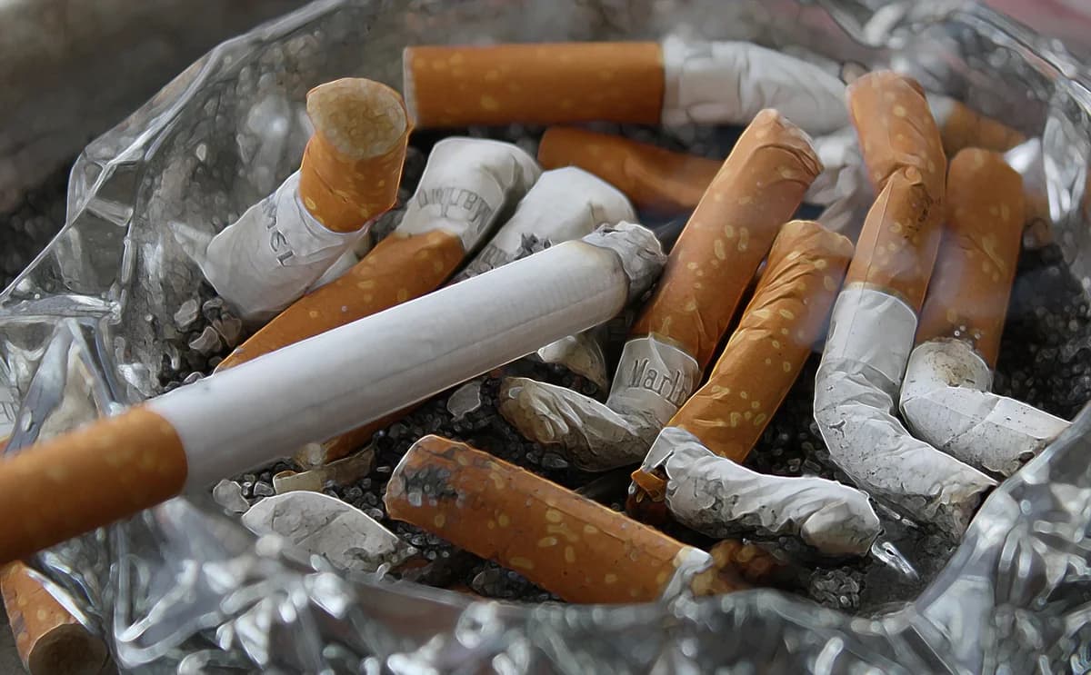 An ashtray filled with cigarette butts and ash.