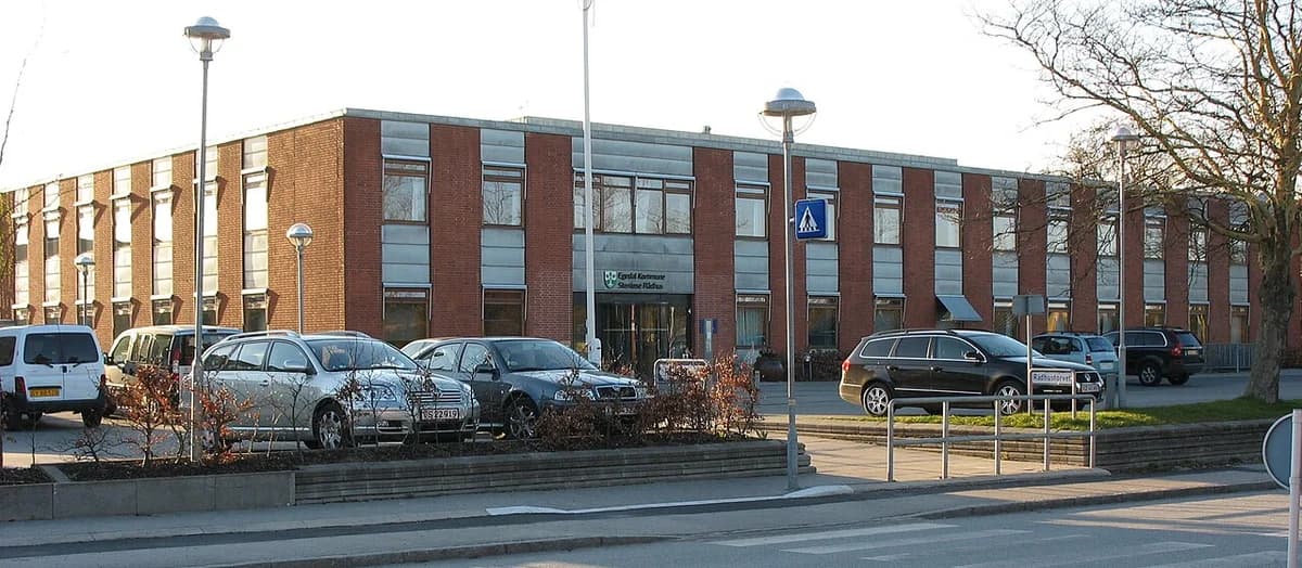 Brick public building with parked cars in front, identified as Stenløse Culture House.