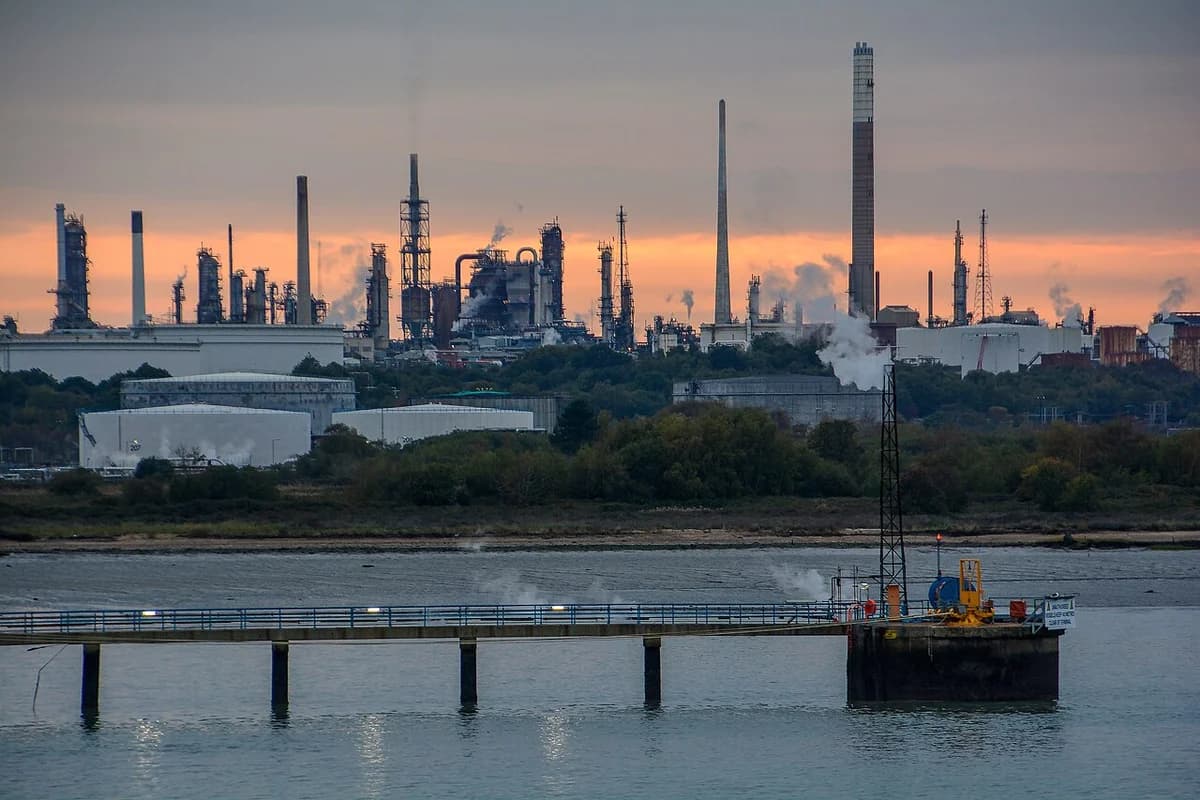 An oil refinery on the coast at sunset.