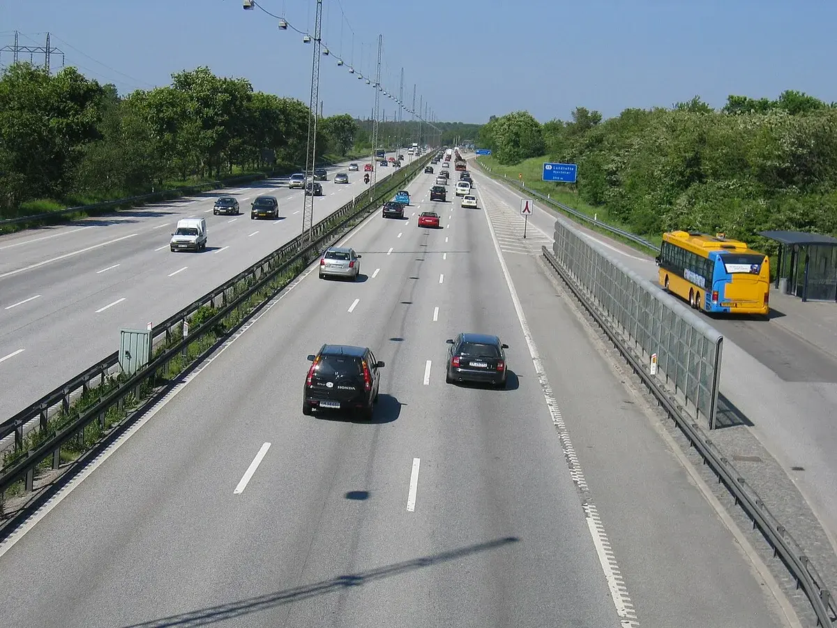 Traffic on a motorway near Copenhagen with a bus stop on the right