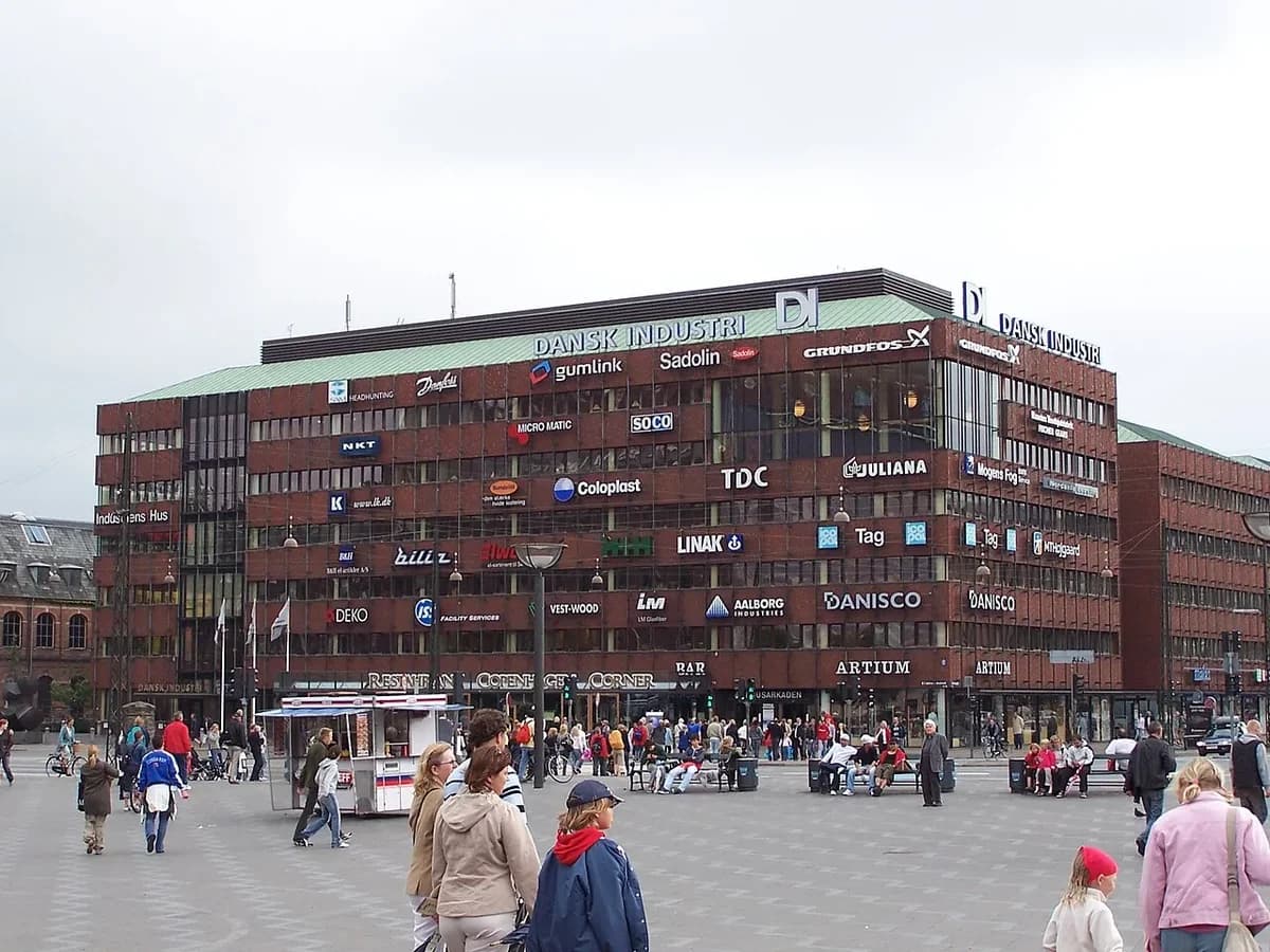 Large office building with Dansk Industri signage and people nearby