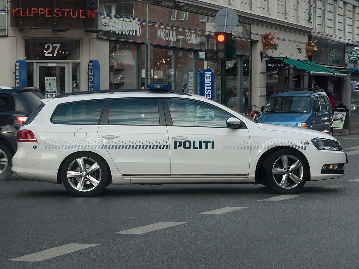 A white Danish police Volkswagen Passat on a city street.