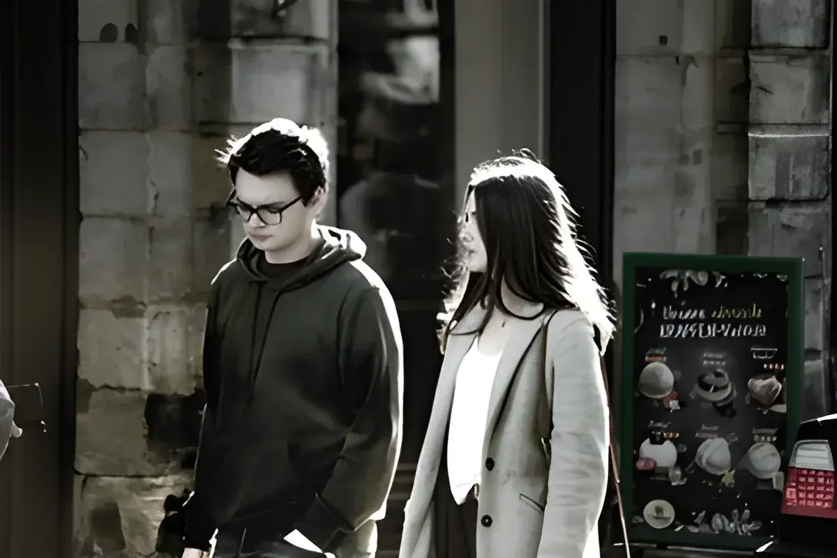 Man and woman walking outside near stone building