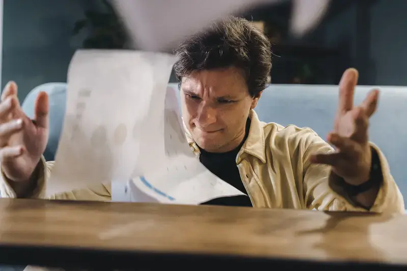 frustrated man throwing papers indoors