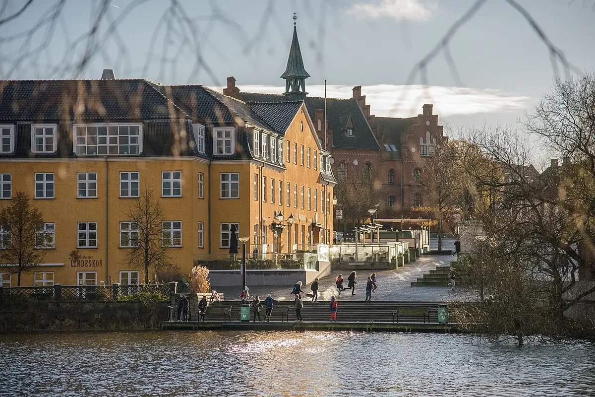 Waterfront promenade in Hillerød with historic buildings and a church spire.