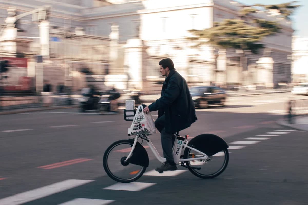 A man riding an electric bike on a city street in Madrid.