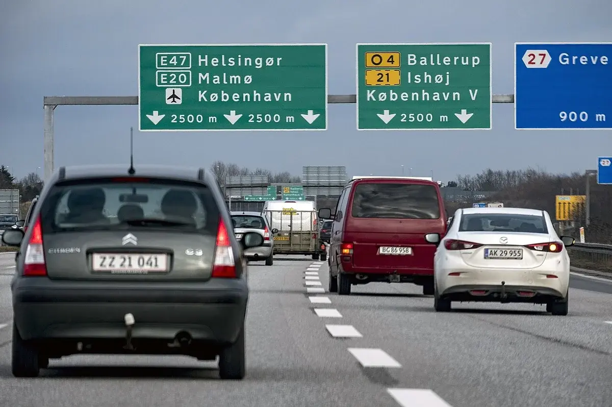 Cars driving on a motorway under signs for E47, E20, Malmo, and Copenhagen.