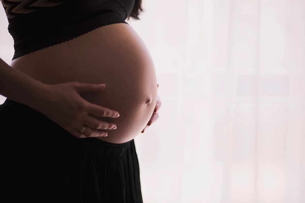 Close-up of a pregnant woman holding her belly.