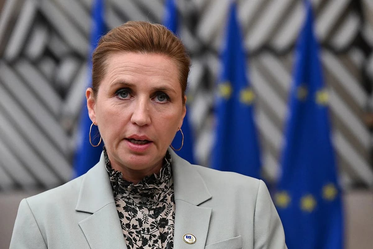 Mette Frederiksen speaking in front of EU flags.