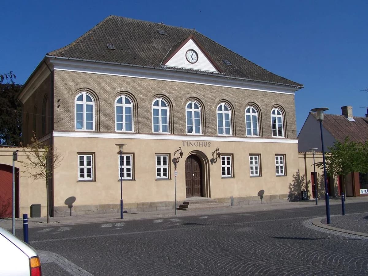 A historic town hall building on a cobblestone street.