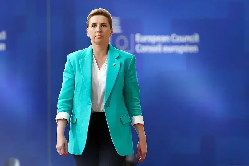 Mette Frederiksen walking in a turquoise blazer at the European Council