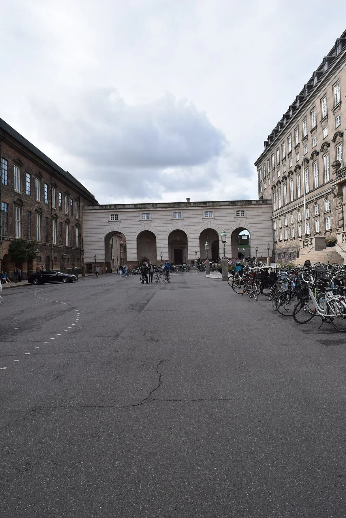 Christiansborg Palace courtyard in Copenhagen with bicycles and people.