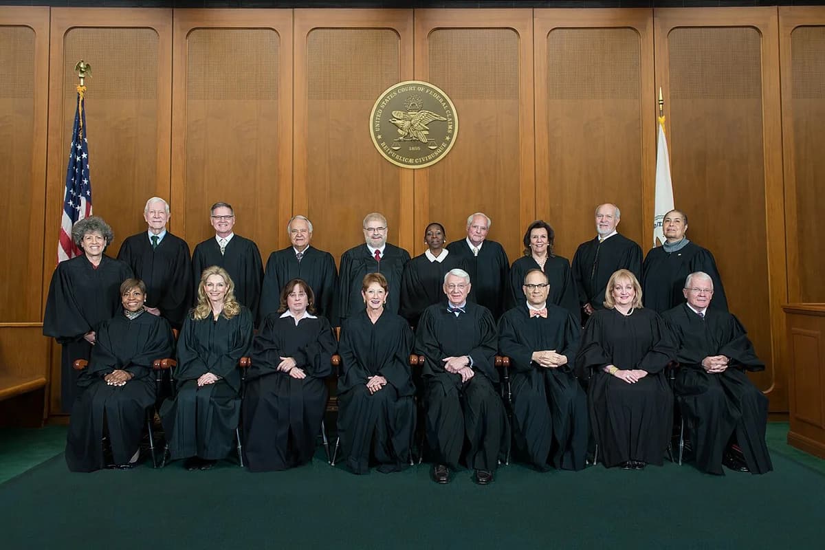 Group portrait of judges in robes inside a courtroom.
