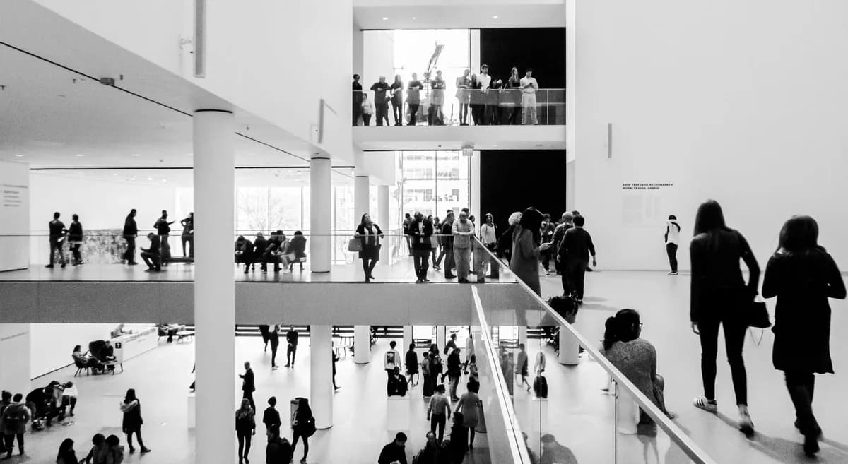 Black-and-white view of visitors in a modern museum interior.